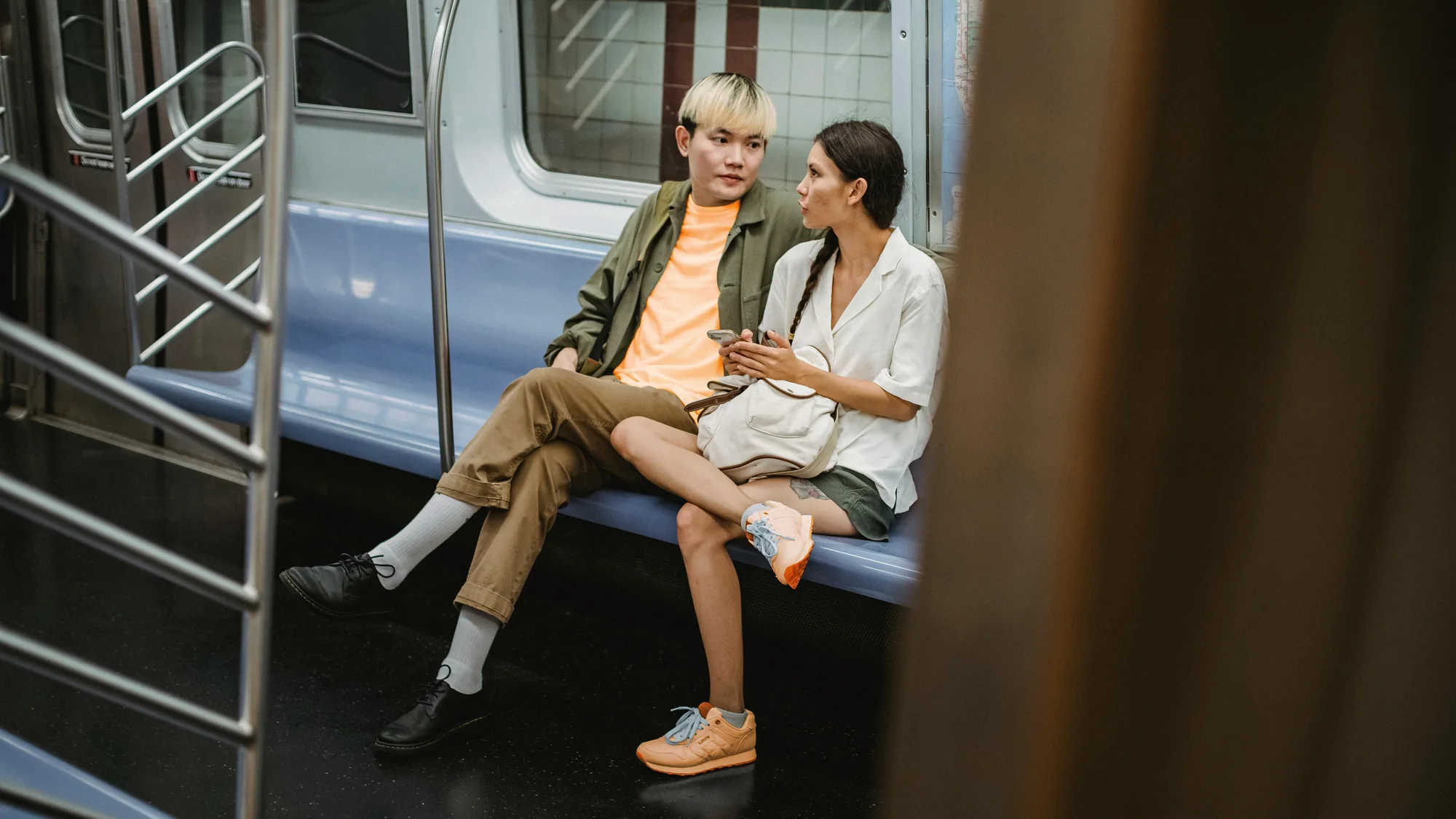 Two people laughing together on a subway train